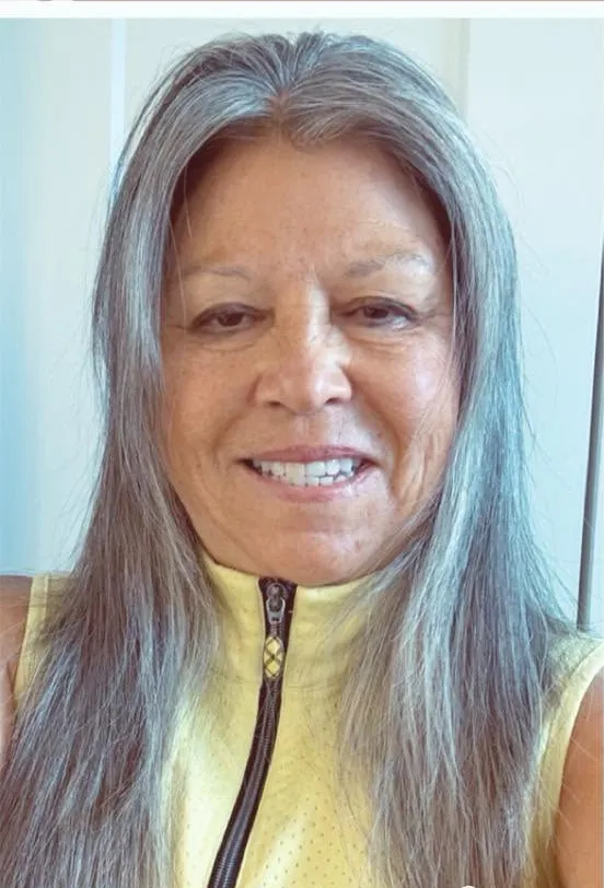 A client before her appointment, long silver-grey hair worn flat and unstyled